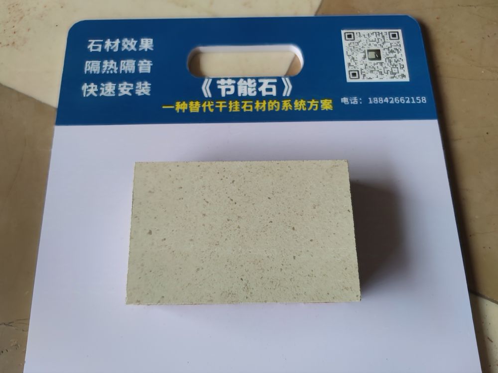 Grey coated fibre-cement faced insulated panel sample on a HUATONG sample card — economical stone-look facade panel